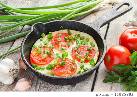 black frying pan with scrambled eggs and tomatoes 15985892