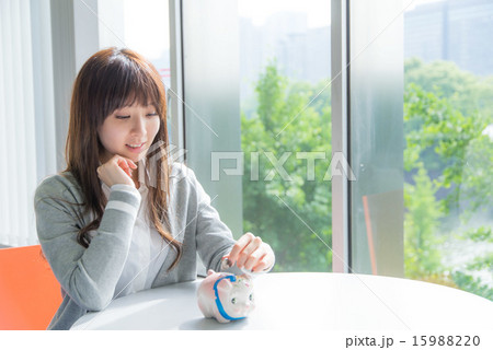 貯金箱と若い女性 貯金箱と若い女性 15988220