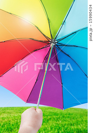 Rainbow umbrella in woman hands on nature Rainbow umbrella in woman hands on nature 15990434