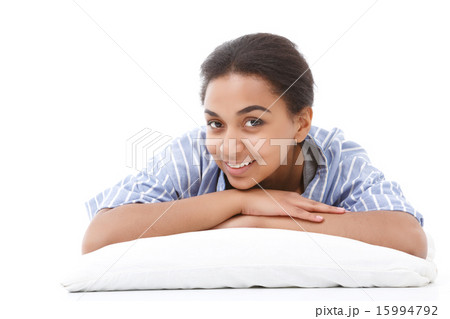 Smiling lying mulatto girl on pillow  15994792