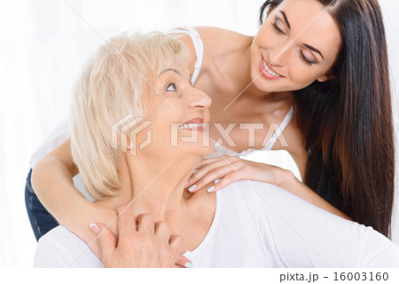 Pretty woman embracing old lady 16003160