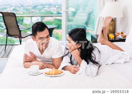 Asian couple having breakfast in bed Asian couple having breakfast in bed 16003318