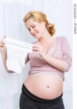 Pregnant woman standing near the window Pregnant woman standing near the window 16003520