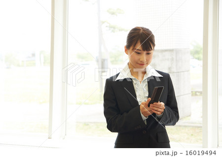 ガラケーでメールチェックする就活生 16019494