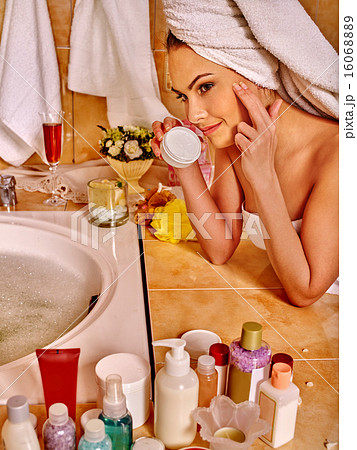 Woman applying moisturizer. 16068889