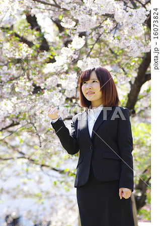 桜の前でガッツポーズする女性 16073824