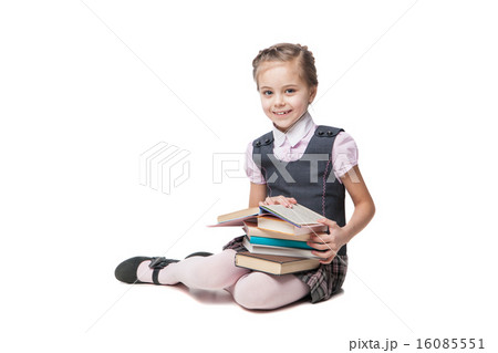 Beautiful little girl in school uniform with books sitting on the floor 16085551