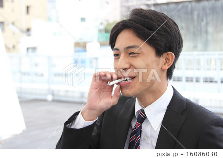 屋上で喫煙する若いビジネスマン 屋上で喫煙する若いビジネスマン 16086030