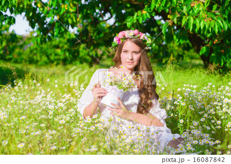 Girl with long hair on the field with daisies  16087842