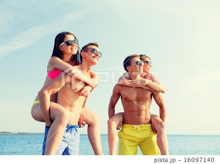 smiling friends in sunglasses on summer beach 16097140