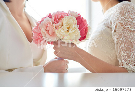 close up of happy lesbian couple with flowers 16097273