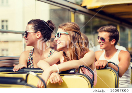 group of smiling friends traveling by tour bus 16097300