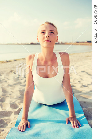 young woman making yoga exercises outdoors 16097579