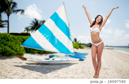 happy woman in bikini swimsuit dancing on beach 16097580