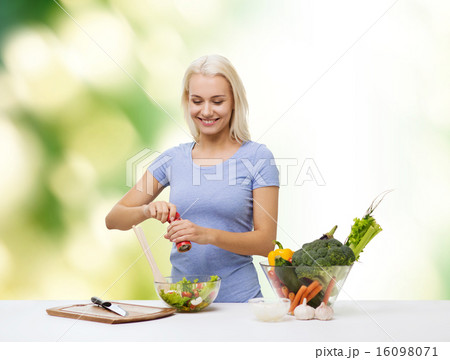 smiling woman cooking vegetable salad 16098071