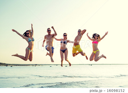 smiling friends in sunglasses on summer beach smiling friends in sunglasses on summer beach 16098152