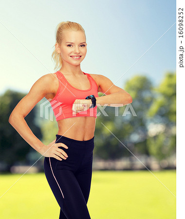 smiling woman with heart rate monitor on hand 16098252