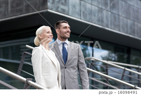 smiling businessmen standing over office building 16098491