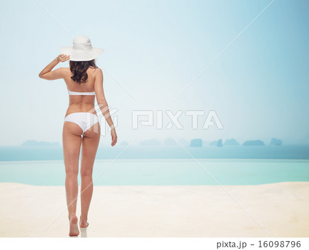 young woman in white bikini swimsuit from back 16098796