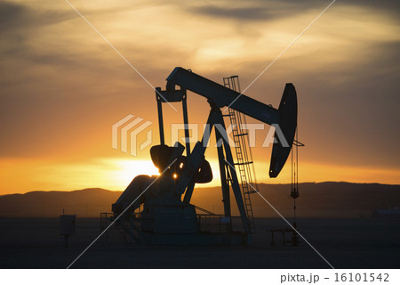 A pumpjack at an oil drilling site at sunset. A pumpjack at an oil drilling site at sunset. 16101542
