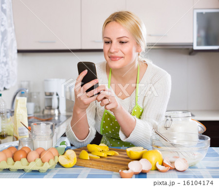 Girl with smartphone at kitchen 16104174