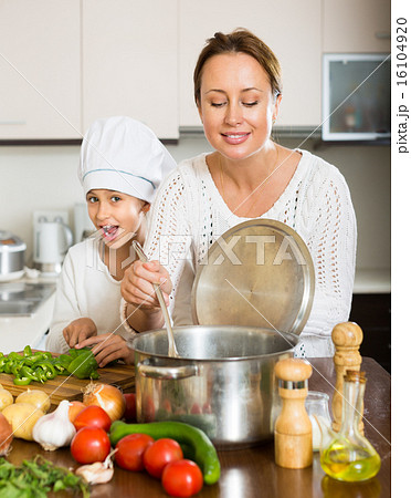 Mother and daughter cooking together 16104920