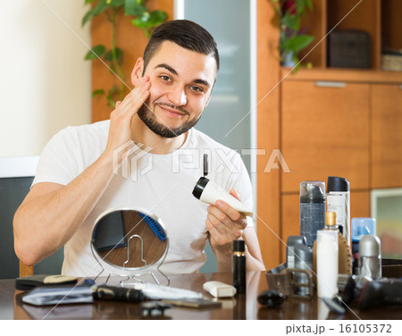 Man applying cream on face skin Man applying cream on face skin 16105372