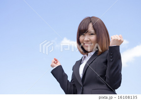 青空を背にガッツポーズするビジネスウーマン 青空を背にガッツポーズするビジネスウーマン 16108135