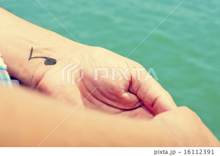 man with a musical note tattooed in his wrist 16112391
