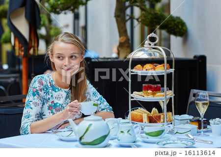 Beautiful young woman enjoying afternoon tea Beautiful young woman enjoying afternoon tea 16113614