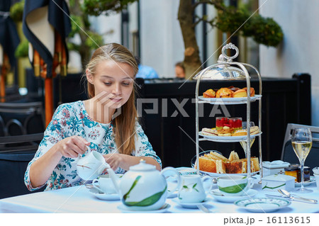 Beautiful young woman enjoying afternoon tea 16113615