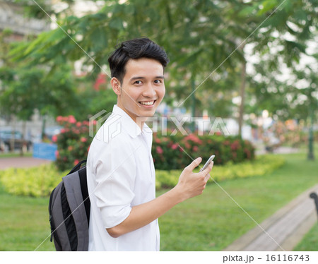 Happy Asian young student using mobile phone 16116743