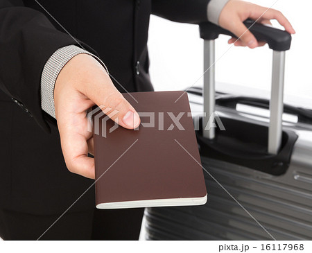 Business traveling pulling suitcase and holding passport Business traveling pulling suitcase and holding passport 16117968