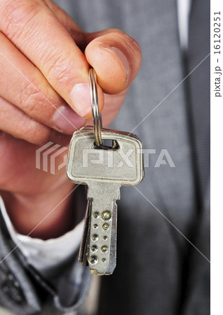 man in suit showing a key ring man in suit showing a key ring 16120251