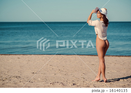 Sexy naked woman posing on the beach 16140135