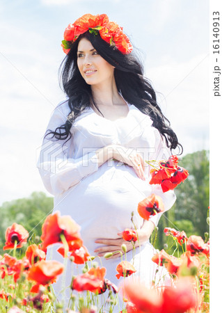 Happy pregnant brunette girl on poppy field Happy pregnant brunette girl on poppy field 16140913