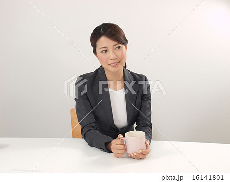 両手で白いコーヒーカップを持つ女性の写真素材