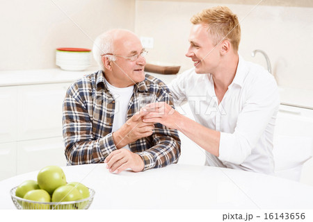 Grandson giving glass with water to his grandpa 16143656