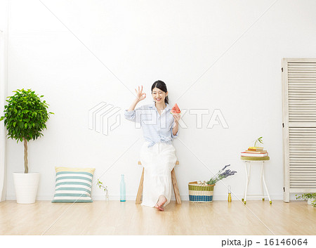 部屋で西瓜を食べる女性　OKサイン 16146064