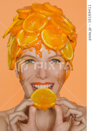 Woman with smile eats  slice of orange 16169411