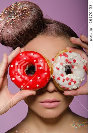 young woman with two donuts before eyes 16170458