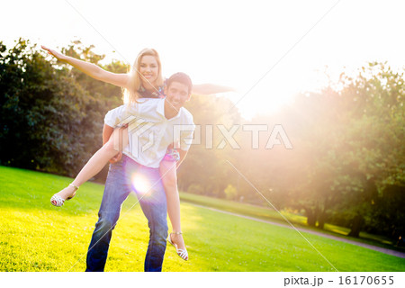 Man carrying girl piggyback in summer 16170655