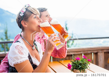 Couple on mountain hut drinking wheat beer 16170701