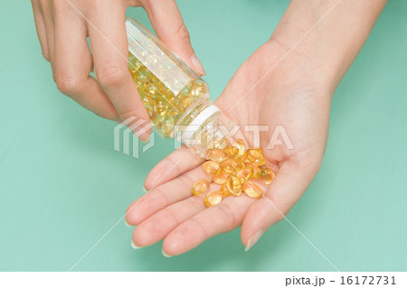 woman 's hand take vitamin Omega-3 fish oil pills 16172731