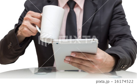 Businessman using the tablet and drinking on white background Businessman using the tablet and drinking on white background 16174522