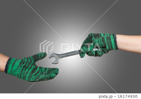 hand holding and sending the wrench on gray background. industri hand holding and sending the wrench on gray background. industri 16174930