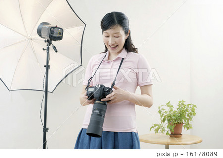 スタジオ 笑顔の女性カメラマンの写真素材