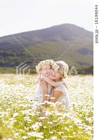 Mother and daugher in field of daisy flowers 16199044