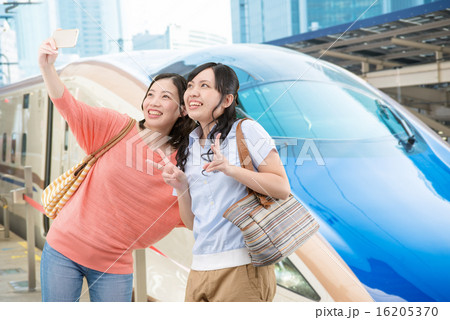 北陸新幹線の前で記念写真を撮っている若い女性2人 16205370