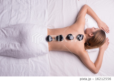 Woman having lastone therapy at spa center Woman having lastone therapy at spa center 16212556
